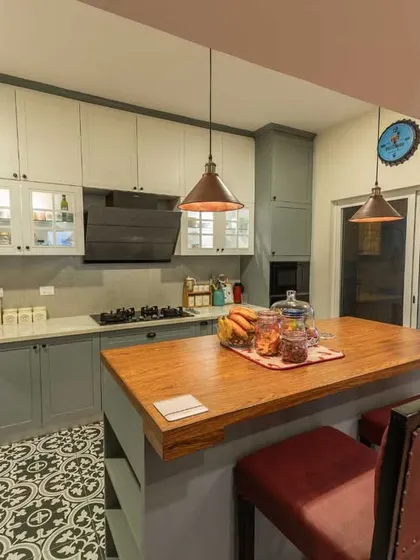 The large wooden island provides ample prep space and casual seating, making the kitchen a social hub.