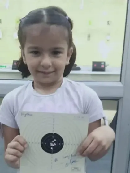 Our little star, all smiles after a good shooting session. We focus on making the sport enjoyable for our youngest members while teaching them discipline.