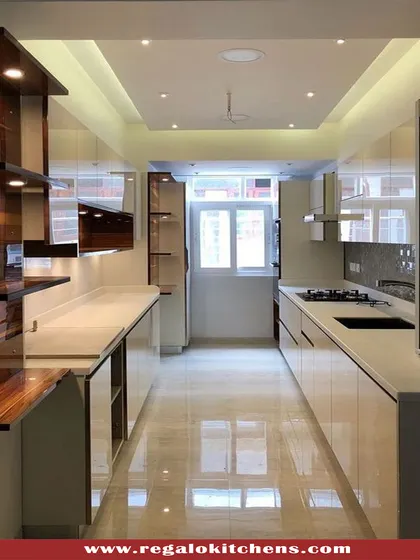 A beautiful example of a parallel kitchen that combines high-gloss white cabinets with dark wood open shelving. The reflective surfaces and strategic lighting make the space feel bright and open, despite its narrow footprint.