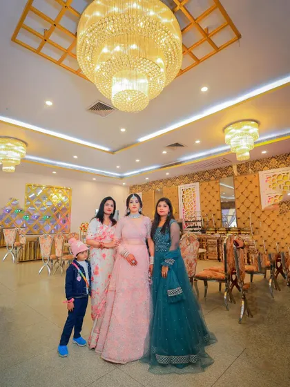 A group photo from a ring ceremony, capturing the couple with their family and friends in the grand venue.