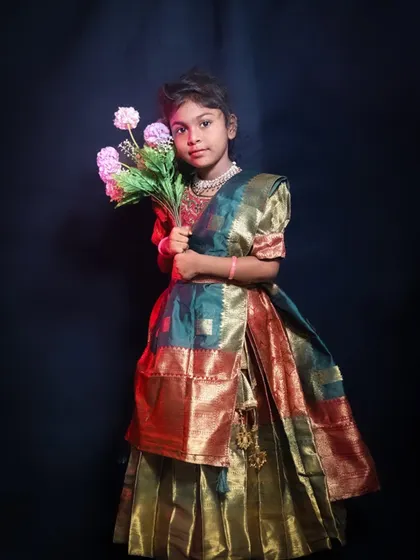 A sweet studio portrait with props. The little girl is holding a bouquet of flowers, and the subtle use of smoke and colored light in the background adds a touch of magic.