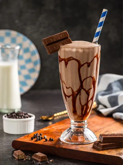 A classic KitKat milkshake, with chocolate syrup drizzled inside the glass and a KitKat bar for garnish.