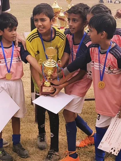 A close-up of our young players with their hard-earned trophy. You can see the focus and pride in their eyes.