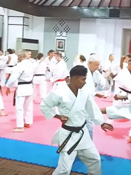 A wide shot of the training floor during the international seminar. You can see karateka of all ages and nationalities practicing together.