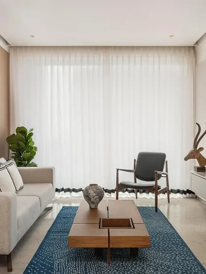 The living room of Apartment 3201, a space designed for a cosmopolitan family. The clean lines, neutral palette, and natural wood tones create a calm and sophisticated atmosphere.