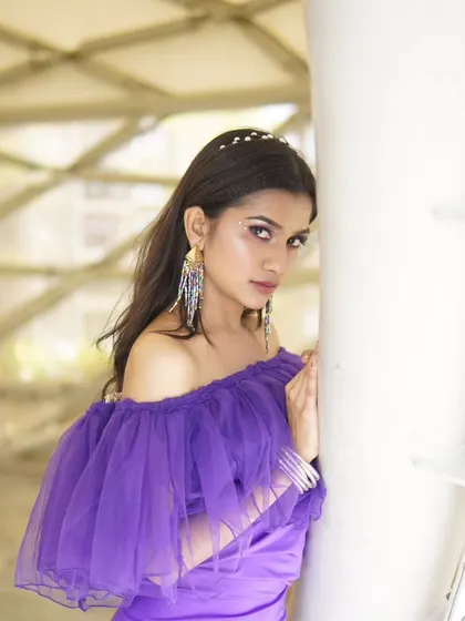 A side profile from the purple gown shoot. The makeup is edgy and modern, with a focus on the creative eye details and sharp contouring.
