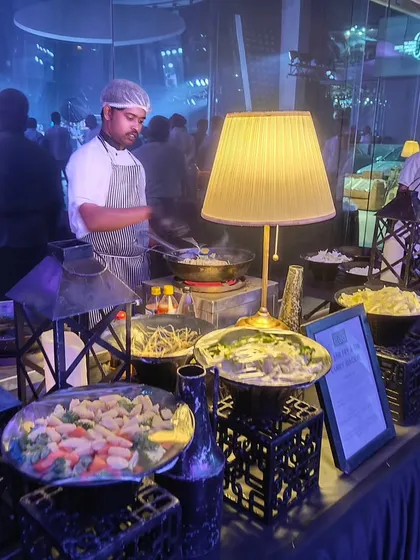 Another angle of our live cooking setup for the Mercedes-EQ launch. We use unique decor like vintage lanterns and lamps to ensure our food stations seamlessly integrate with the event's overall aesthetic.