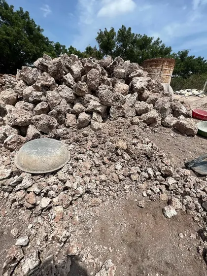 A pile of limestone chunks before being fired in the kiln. This is the raw material, straight from the earth, that will become the breathable plaster on our walls.