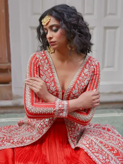 A close-up of the intricate silver embroidery on the red jacket lehenga. The craftsmanship is what makes these pieces so special and luxurious.
