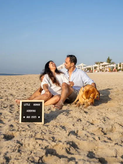 A joyful beach maternity announcement from a shoot in Dubai. The happy couple and their Labrador, Astro, are all smiles as they share their exciting news.
