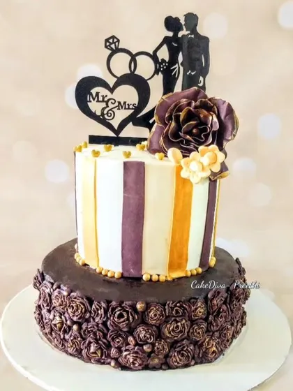 This unique engagement cake features a bas-relief technique on the bottom tier, creating a subtle, artistic texture. The top tier's bold stripes and the chocolate rose rosettes on the bottom offer a beautiful contrast in styles.