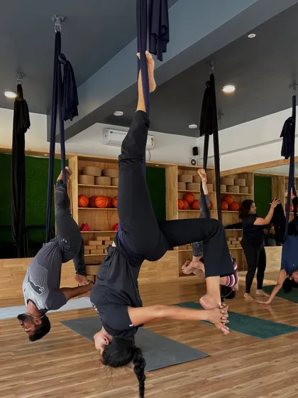 A group of students in a synchronized inverted pose. The visual harmony of the class reflects the collective energy and focus.