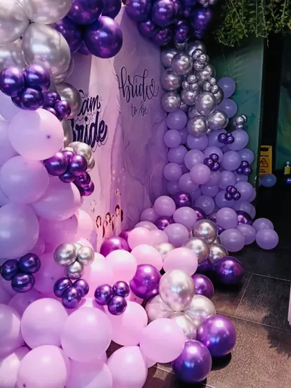A closer look at the cascading balloon arrangement for the bridal shower. I love mixing different shades and sizes of balloons, like these lilac, purple, and chrome ones, to create depth and a sense of abundance.