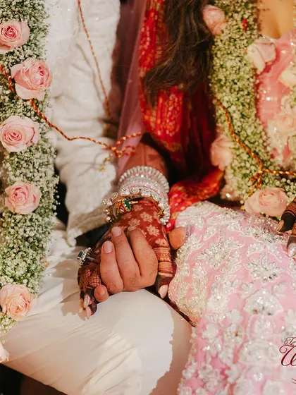 The couple holding hands during the ceremony, a simple yet powerful symbol of their partnership.