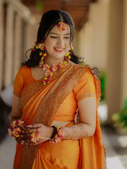 A lovely portrait of the bride, her smile as bright as the flowers in her jewelry.