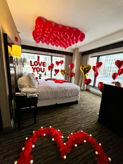A wider view of our classic romantic setup, showing a rose petal heart pathway leading to the beautifully decorated bed. This gives you a sense of how we transform the entire space.