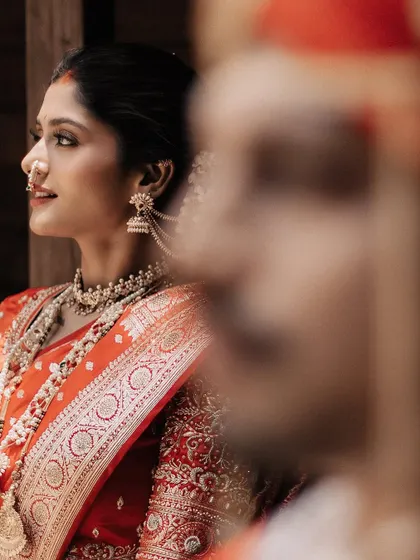 A beautiful profile shot of the bride, her intricate jewelry and saree details perfectly captured.