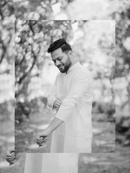 An artistic black and white portrait of the groom getting ready, with a creative frame effect.