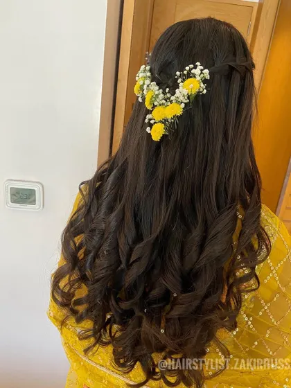 I created this fresh and simple half-updo for a Haldi ceremony, using bright yellow flowers and baby's breath to complement the bride's yellow outfit.