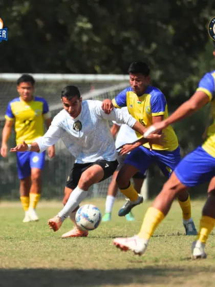 Surrounded by defenders, our player skillfully maneuvers to keep possession and find a teammate.