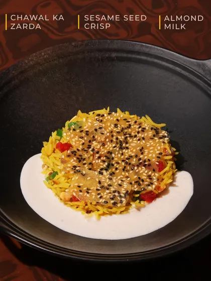 An annotated image of our Chawal ka Zarda, highlighting its key components: the sweet rice, the crunchy sesame crisp, and the creamy almond milk.