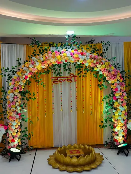 The Haldi stage illuminated with spotlights, making the colors pop and creating a festive ambiance.