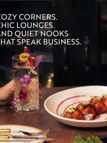 A beautifully garnished drink and appetizers in a chic lounge setting. This image showcases the cozy corners and quiet nooks that speak business in a relaxed and stylish environment.