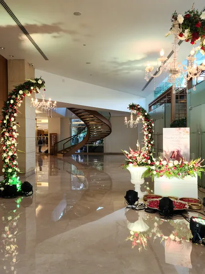 This stunning lobby transformation features curving floral arches accented with crystal chandeliers. The design guides guests through the space and creates multiple beautiful photo opportunities.