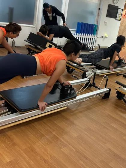 Various shots of members and instructors in action during our dynamic Reformer Pilates classes.