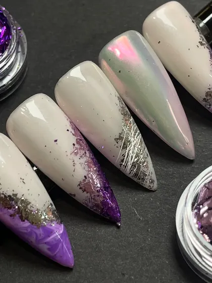 A purple paradise. This flawless set of nails with purple foil and chrome accents was created by our talented nail trainer.