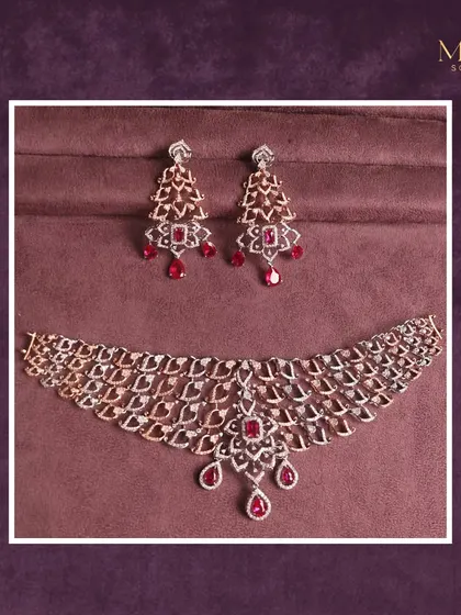 A masterpiece of elegance and grace. This intricate diamond necklace is accented with rich red rubies, creating a look that is both regal and breathtaking. The matching earrings complete this stunning set.