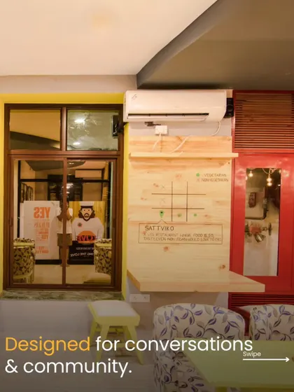 This nook in the cafe is designed for conversations and community. The interactive tic-tac-toe board on the wall and the comfortable, patterned seating create a playful and engaging corner for guests to enjoy.
