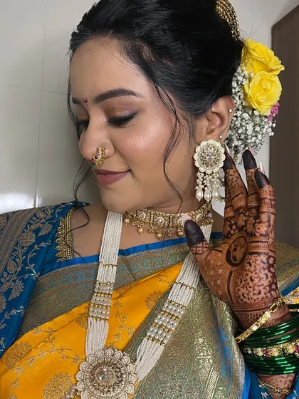 A close-up showcasing the intricate henna, the floral hair accessories, and the glowing, natural makeup.