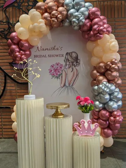 A chic bridal shower with a beautiful balloon arch in rose gold, peach, and silver, perfect for celebrating the bride-to-be.