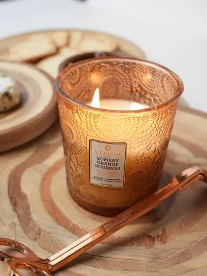 The warm, inviting scent of our Bombay Orange Bourbon candle, captured in a hand-cut glass jar. The intricate pattern on the glass glows beautifully when lit, making it a centerpiece of warmth and style.