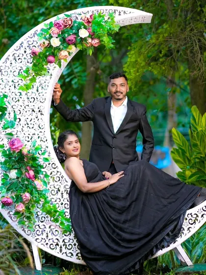 Another lovely shot with the crescent moon prop. This pose captures the couple looking at each other, framed by the moon and flowers.