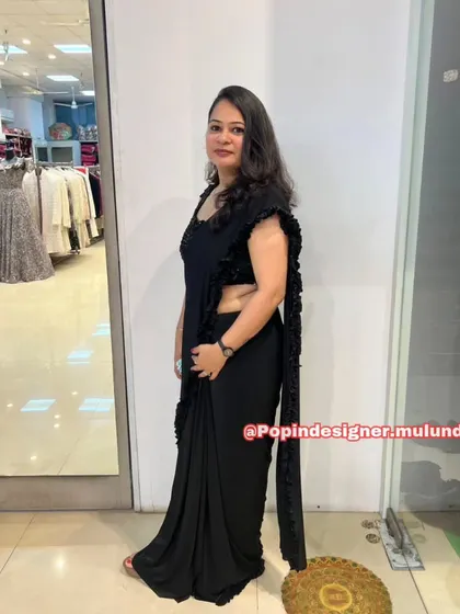 A side view of the black ready-to-wear saree, showing how the ruffles cascade down the edge for a modern and dramatic effect.