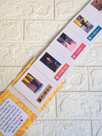 The slider card fully extended, revealing the series of five photos, each paired with a different song that tells your story.