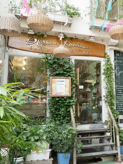 My salon entrance is an invitation to step into a world of natural beauty and calm. The lush plants and wooden sign set a welcoming, earthy tone.