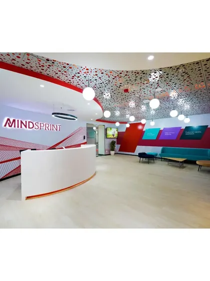 Another view of the Mindsprint reception, showing the waiting area and the dynamic, perforated ceiling pattern. The design ensures a cohesive and immersive brand experience from the moment someone steps in.