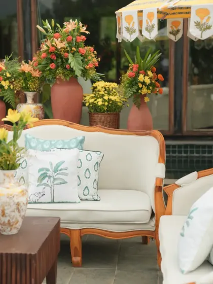 The complete lounge seating arrangement, combining elegant wooden furniture with vibrant floral displays and custom textiles for a relaxed yet chic vibe.