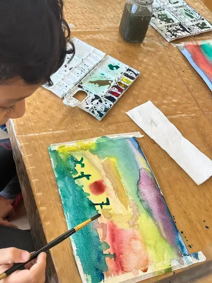 A student carefully works on a watercolor painting during an offline class. These focused moments are where skills are honed and personal style begins to emerge.