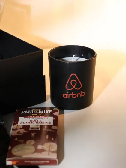 A branded scented candle and a bar of artisanal chocolate from the Airbnb hamper. I focus on sourcing high-quality items from other great brands to elevate the gifting experience.