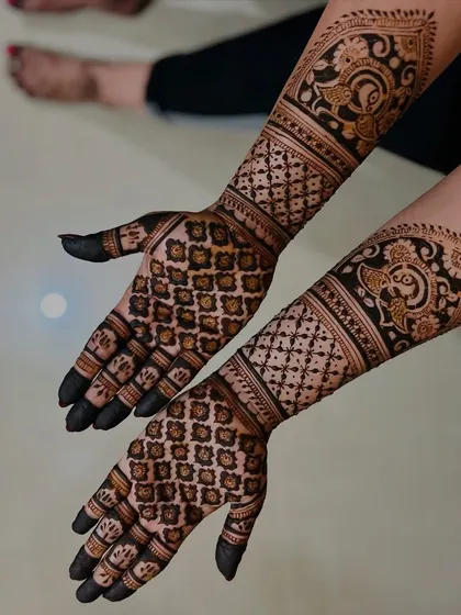 This design features a dense floral grid on the palms, complemented by paisley motifs on the forearms.