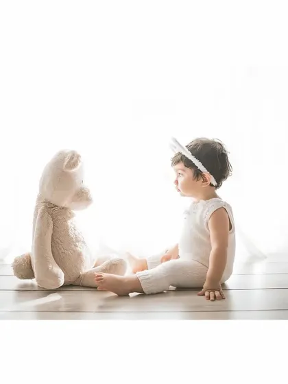 A quiet conversation between friends. This side profile shot of a baby and a teddy bear is simple, sweet, and full of innocence.