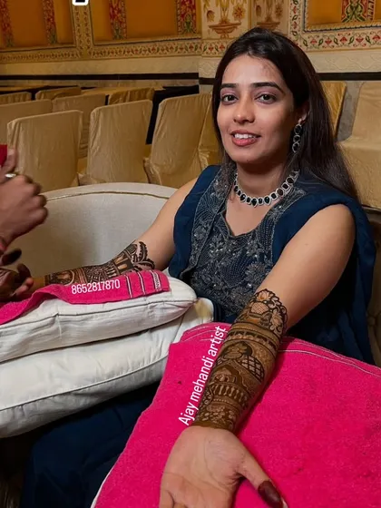 We focus on making our clients comfortable and happy during the application process. Here, a bride smiles for the camera while we carefully apply her intricate wedding henna.