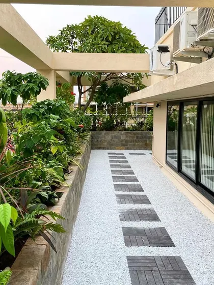 This angle shows the practical side of the corporate terrace design, with space for AC units neatly integrated without disrupting the aesthetic of the garden walkway and planters.