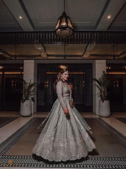 A beautiful full-length portrait of the bride in her glamorous cocktail outfit, twirling in the grand lobby of the venue.