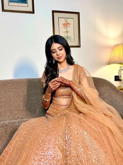 A candid moment showing the bride's henna. Her makeup looks soft and beautiful, even in a relaxed pose.