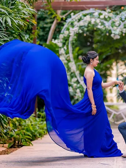 A classic proposal moment, elevated by the drama of the flowing blue gown. This shot, set against a heart-shaped arch, is the perfect way to capture the beginning of your forever.